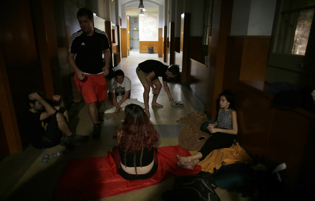 Gente descansando dentro de la escuela secundaria Miquel Tarradell, uno de los centros de votación designados para el disputado referendo del 1 de octubre sobre la independencia de la región española de Cataluña, en Barcelona, (AP Photo/Manu Fernandez)