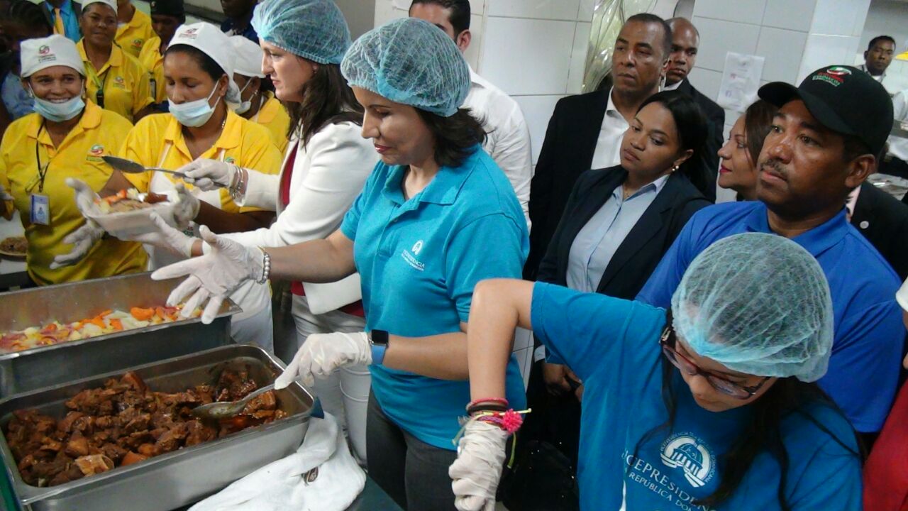 Margarita Cedeño de Fernández sirve alimentos a usuarios en visita a sede Comedores Económicos.