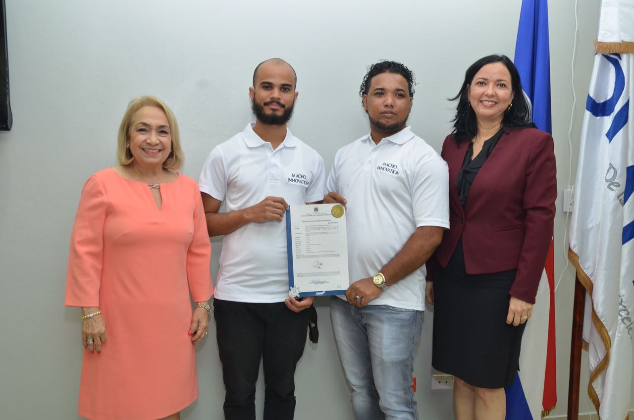 Los jóvenes José Alfonso Plácido Tineo y Wuady José Polanco, recibieron la patente de las manos de Sandy Lockward, directora de ONAPI y de Alma Fernández, directora General de Proindustria.